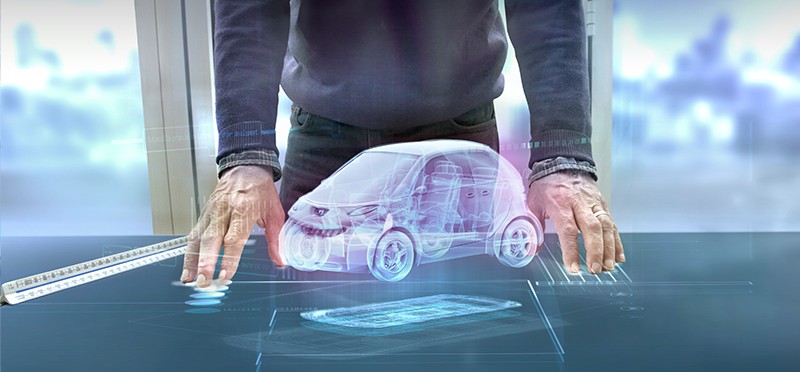 Digital image of a car on a table, in between two hands