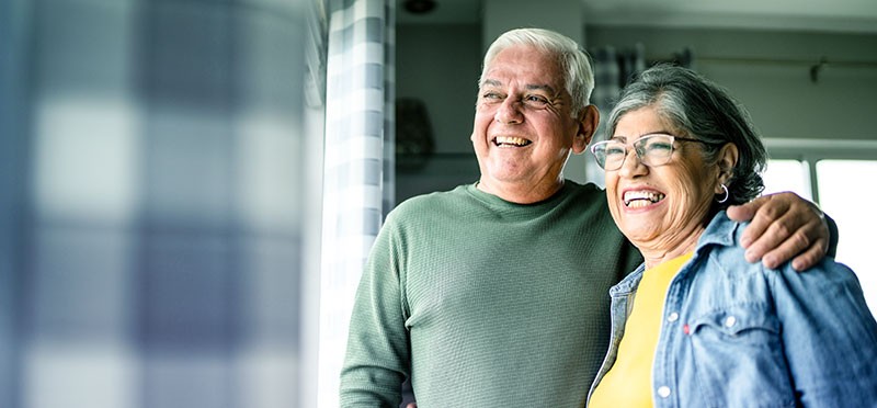 Smiling older couple looking out a window
