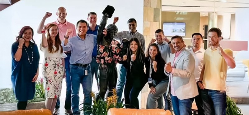 Group of people smiling and cheering in an office 