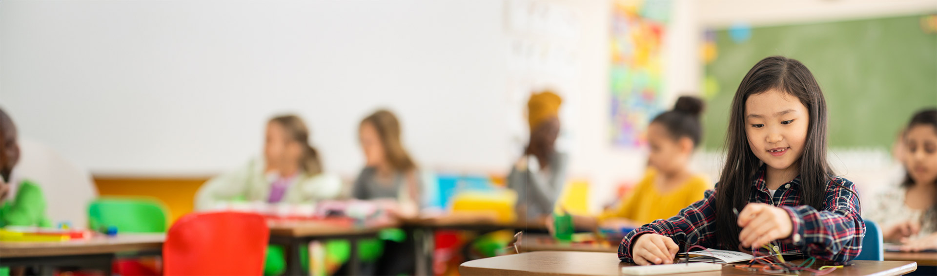 Young girl with an electronics kit in a classroom