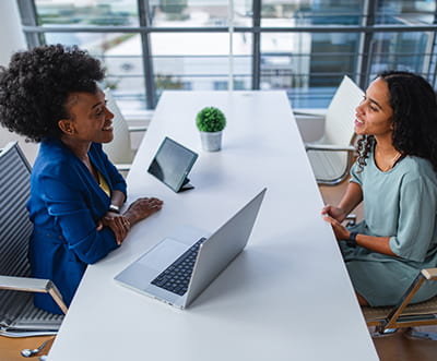 Two women having a conversation at a work desk