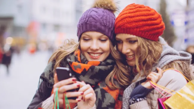 2 friends looking at the same phone
