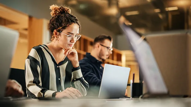 Woman sitting and working at a laptop