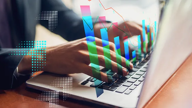 Hands typing on a laptop with a graphic of a bar chart rising from the keyboard