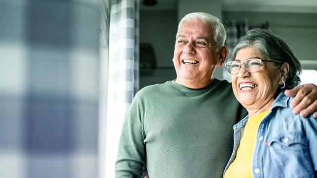 Smiling older couple looking out a window