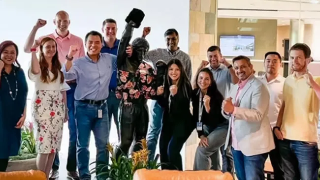 Group of people smiling and cheering in an office 