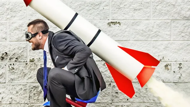 Man riding a tricycle with a rocket on his back