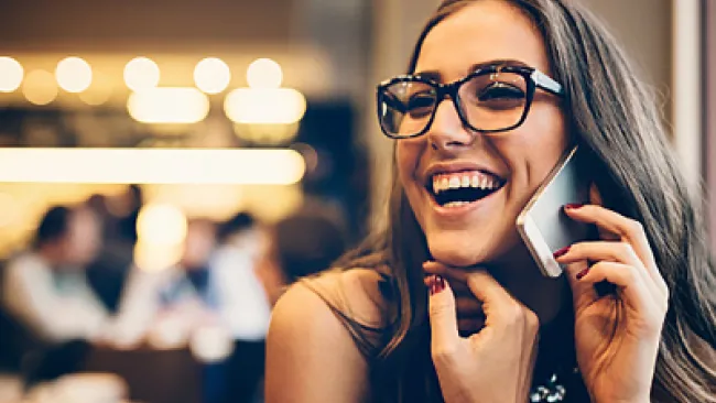 A woman happily talking to someone over the phone