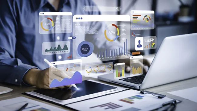 Charts and graphs hovering over a laptop someone is working on