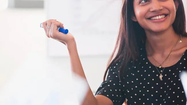 Woman holding a sharpie marker in a conference room