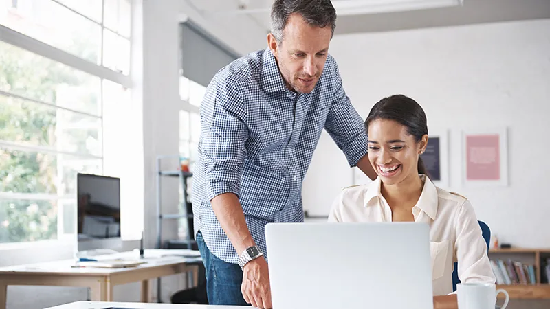 A guy showing his colleague where to find the knowledgebase