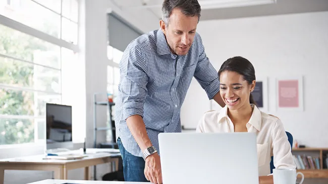 A guy showing his colleague where to find the knowledgebase