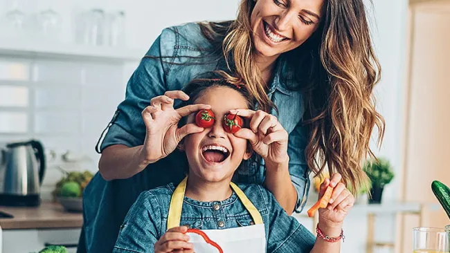 Mother in kitchen cooking with child