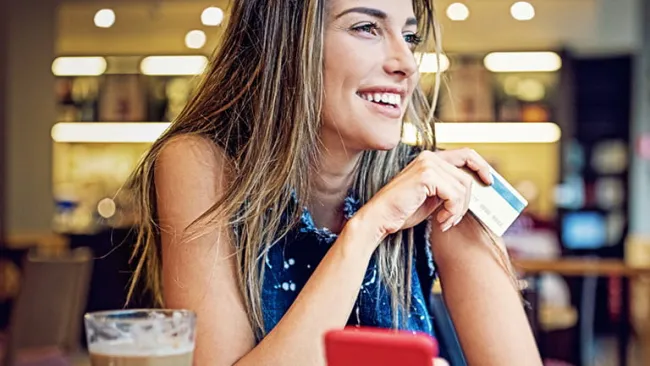 Woman holding phone while shopping