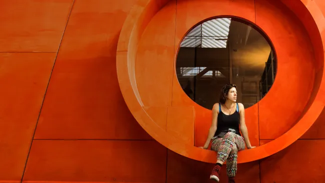 Woman sitting on artistic bench that is built into the wall