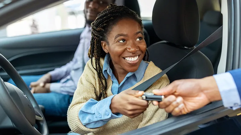 Woman receiving the key for a new car