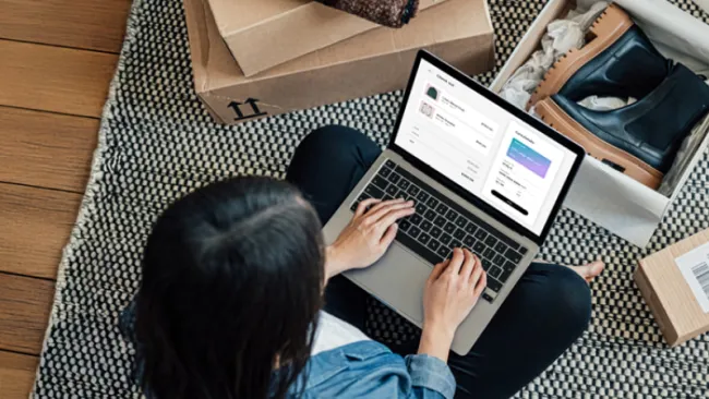 Woman sitting on the floor and shopping on her laptop