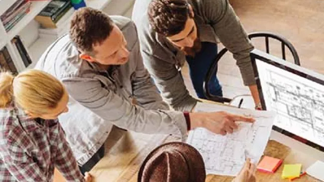 Group of employees looking at architectural drawings