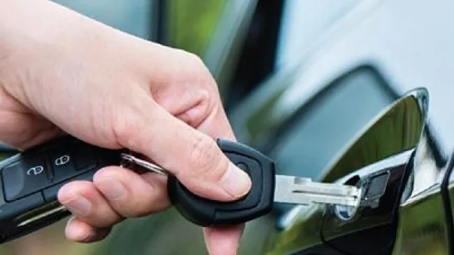 Person putting a key into their car door