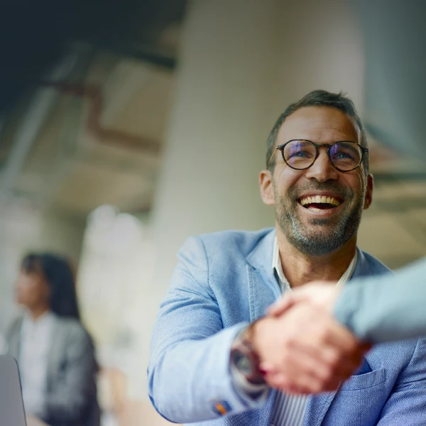 Man in a suit shaking another person's hand
