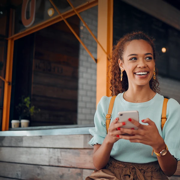Woman sitting outside on her phone