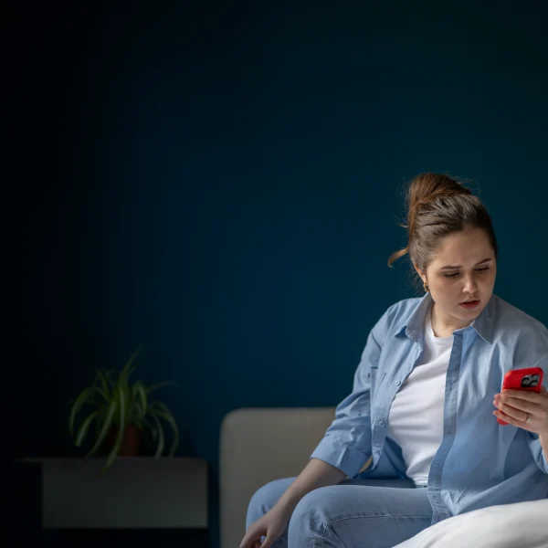 Customer on their phone while sitting on a couch
