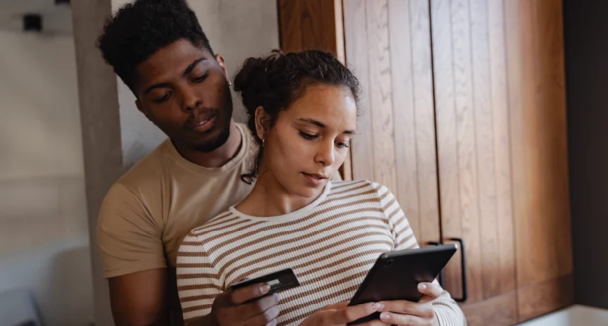 A couple sharing a phone to make a payment